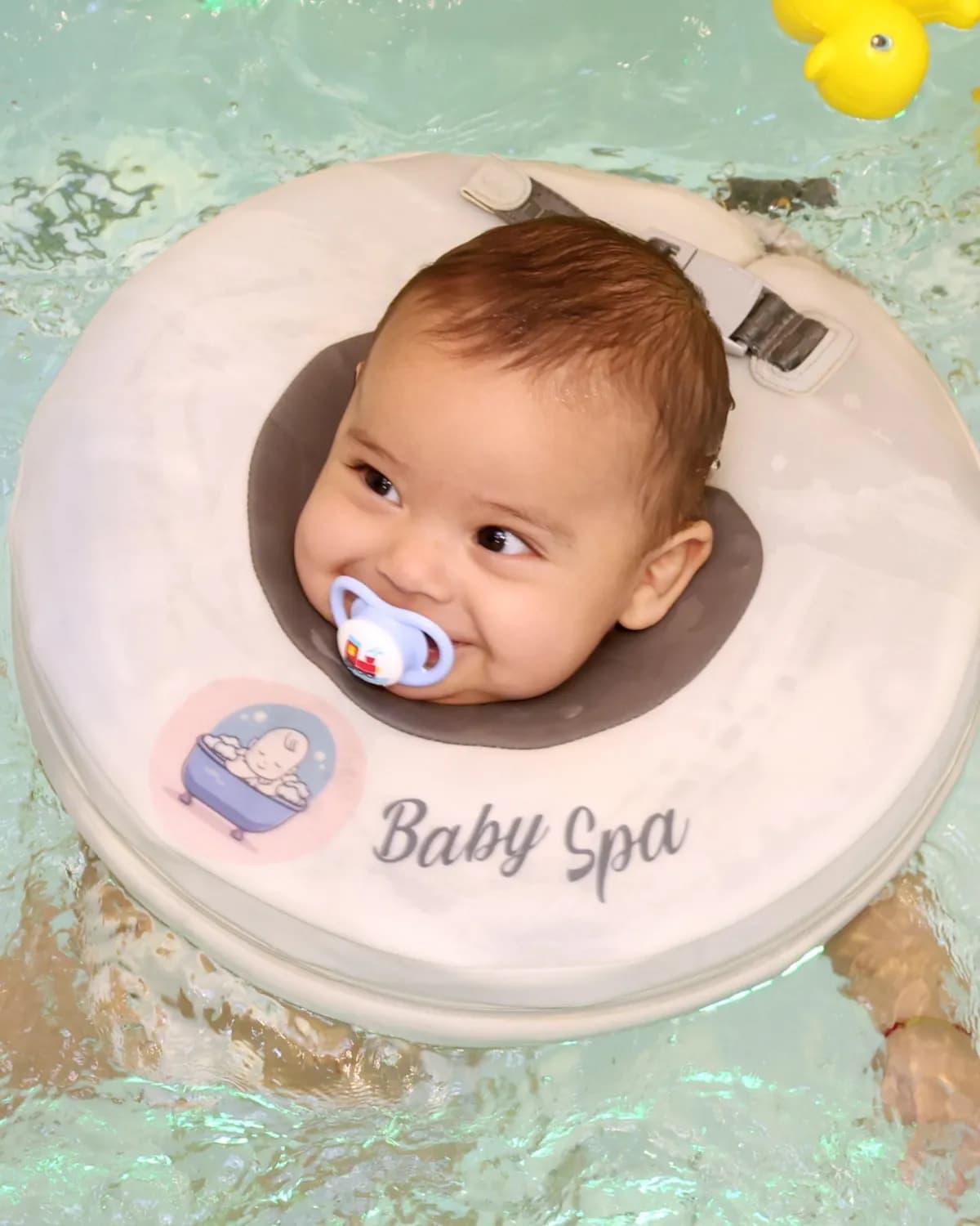 Bebê flutuando com apoio de boia cervical
