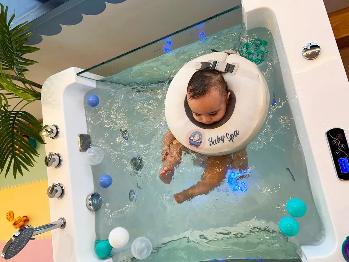 Bebê explorando o movimento na banheira de vidro, visto de cima